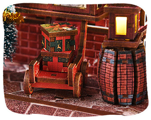 Little cart piled with wrapped gifts beside a brick barrel